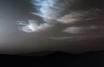 Clouds drift slowly across the morning sky on Mars, creating a rare and mesmerizing sight.